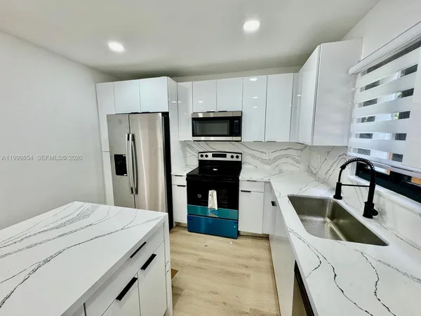 a kitchen with stainless steel appliances a refrigerator sink and microwave