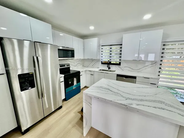 a kitchen with stainless steel appliances a refrigerator sink and microwave