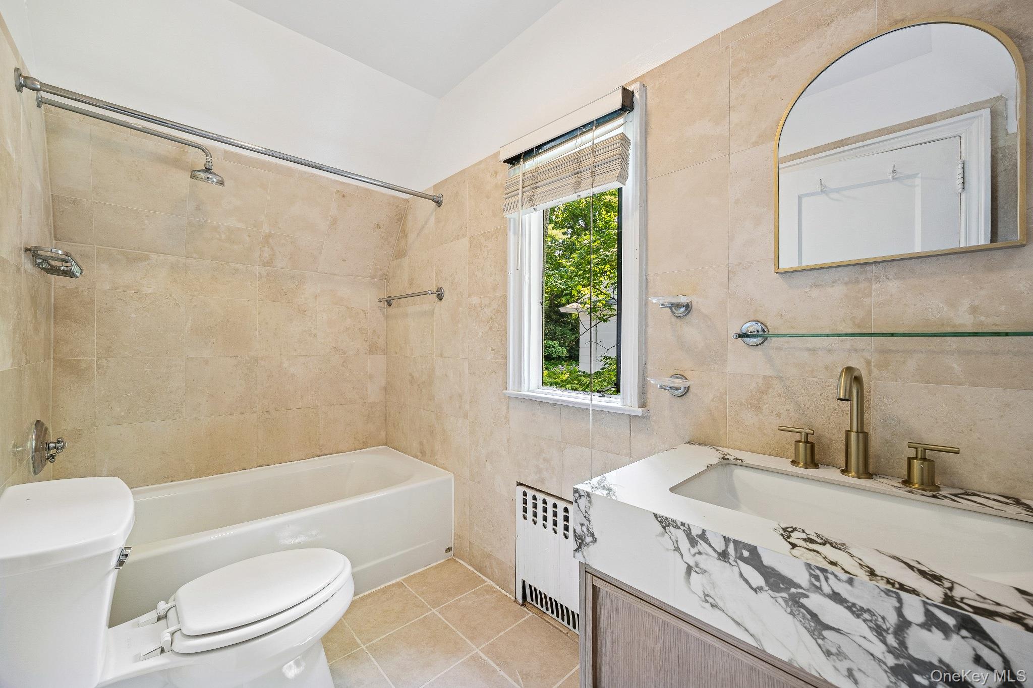 10 River Road Scarsdale, NY 10583 - Photo 17 of 20 Full bath featuring tile walls, tile patterned floors, vanity, radiator, and shower / washtub combination