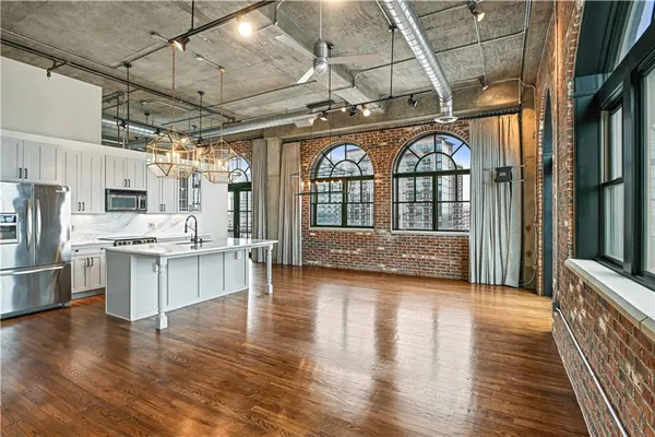 a view of kitchen with stainless steel appliances granite countertop cabinets and wooden floor