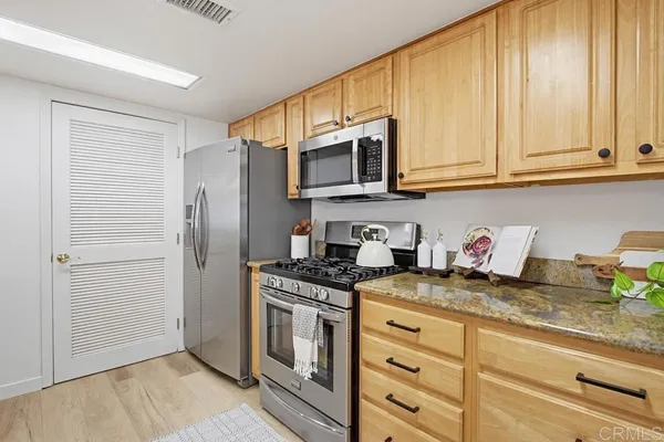 a kitchen with granite countertop cabinets stainless steel appliances and a sink