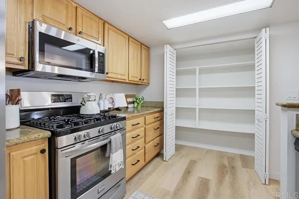 a kitchen with stainless steel appliances granite countertop a stove and a microwave