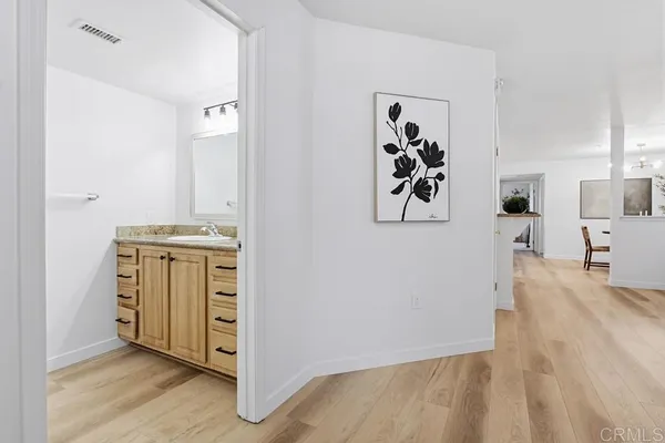 a view of a hallway with wooden floor and closet