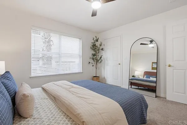 a bedroom with a large bed and a chandelier