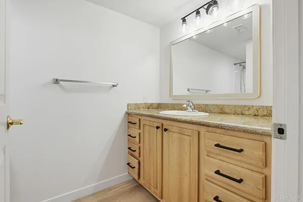 a bathroom with a granite countertop sink and a mirror