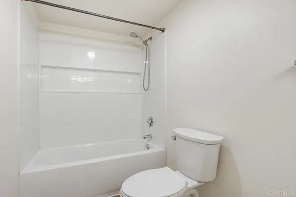 a white toilet and tub sitting next to a bathroom sink