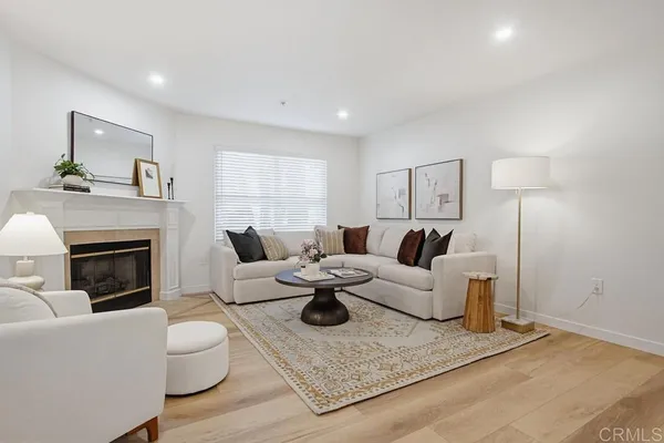 a living room with furniture a fireplace and a potted plant