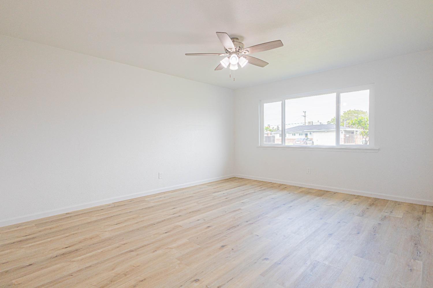 852 West San Gabriel Avenue Clovis, CA 93612 - Photo 2 of 16 a view of an empty room with wooden floor and a window