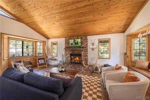 a living room with furniture a fireplace and a floor to ceiling window