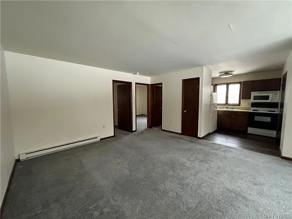 a view of an empty room with a kitchen