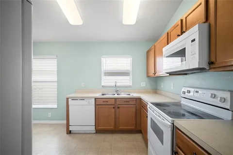 a utility room with stainless steel appliances granite countertop a sink and a window