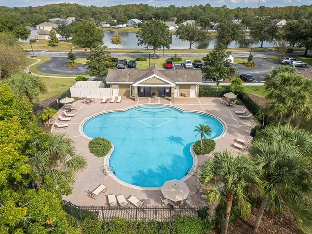 an aerial view of a house with swimming pool and mountains