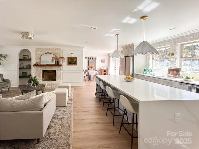 a large living room with couches a dining table and chairs with wooden floor