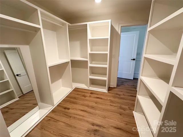 a view of an empty room with wooden floor and staircase