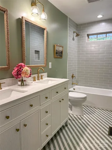 a bathroom with a double vanity sink mirror and toilet