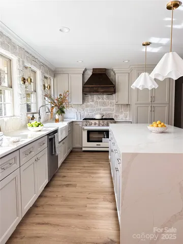 a large kitchen with stainless steel appliances kitchen island granite countertop a sink and a stove