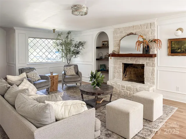 a living room with furniture a fireplace and potted plants