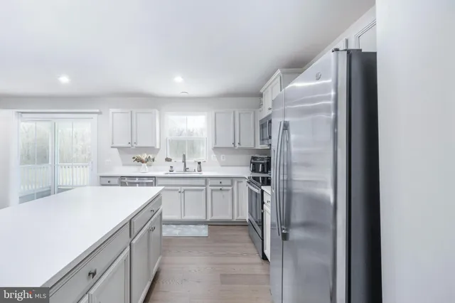 a kitchen with white cabinets and white appliances