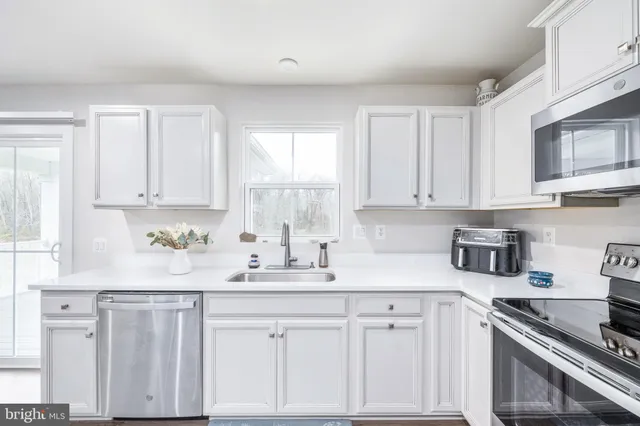 a living room with furniture and view of kitchen