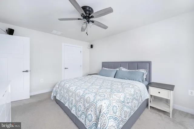 a bedroom with a bed and a ceiling fan