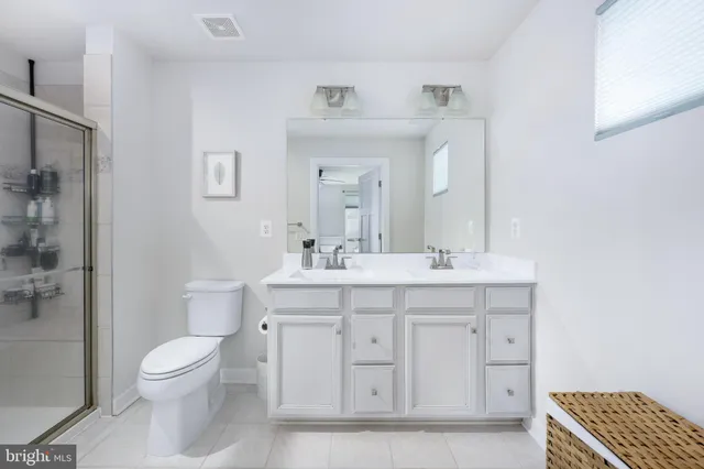 a bathroom with a toilet a sink a mirror and a shower