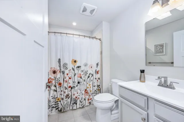 a bathroom with a shower curtain sink and a toilet