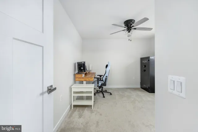a view of a livingroom with a chair and a ceiling fan