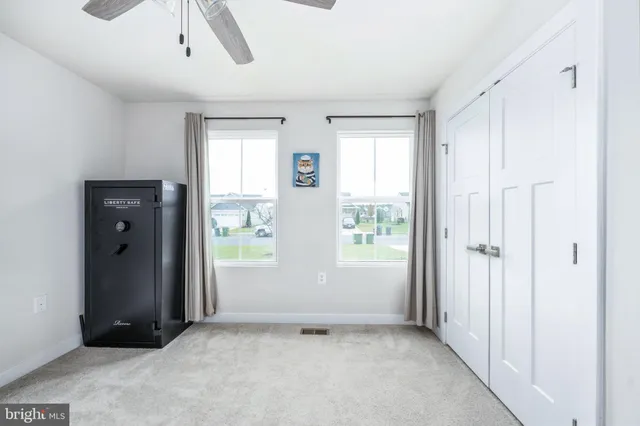 a view of an empty room with window and cabinet area