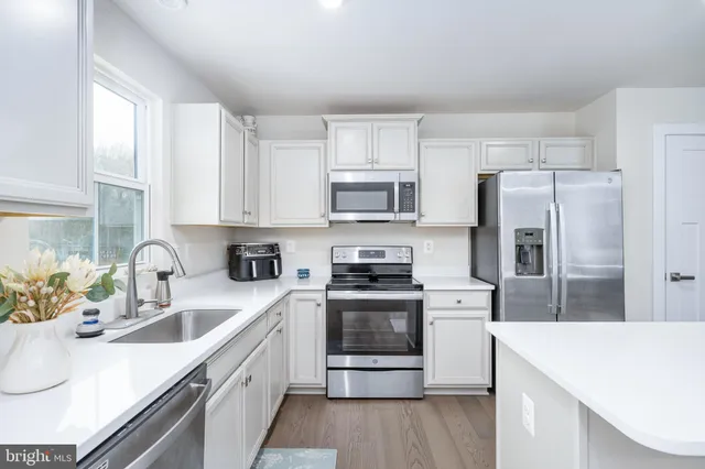 a kitchen with a sink a stove top oven and refrigerator