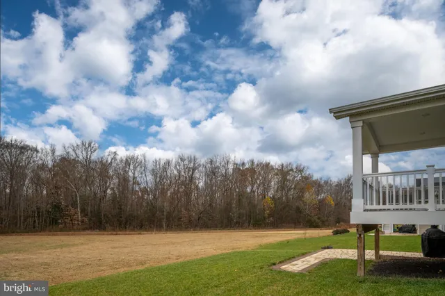 an aerial view of a houses with outdoor space and trees all around