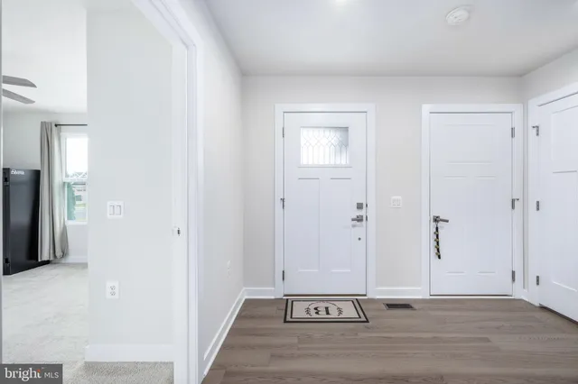 a view of a hallway with a dining table and chairs