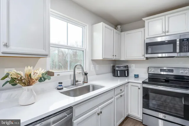 a kitchen with white cabinets and stainless steel appliances