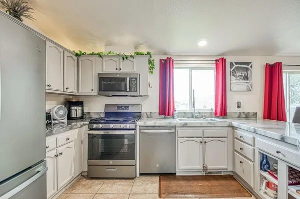 a kitchen with granite countertop a stove top oven sink and cabinets