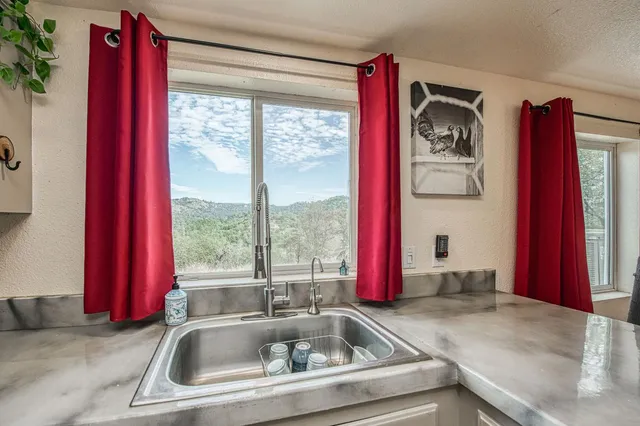 a kitchen with a window and red door