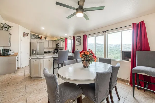 a kitchen with stainless steel appliances kitchen island granite countertop a table chairs in it and wooden floors