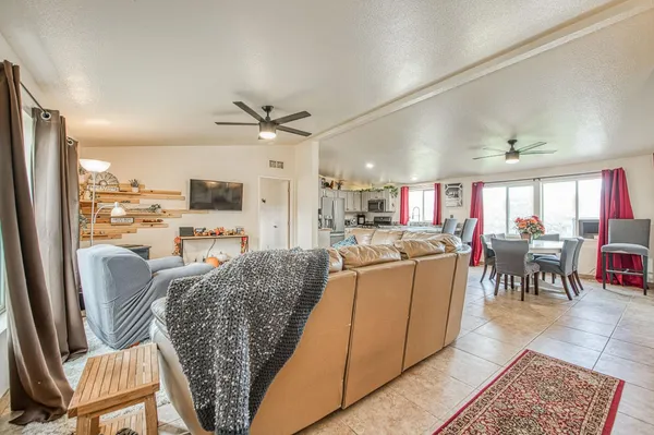 a living room with furniture a fireplace a flat screen tv and a kitchen view
