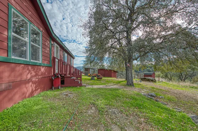 a view of house with a yard and mountain view in back