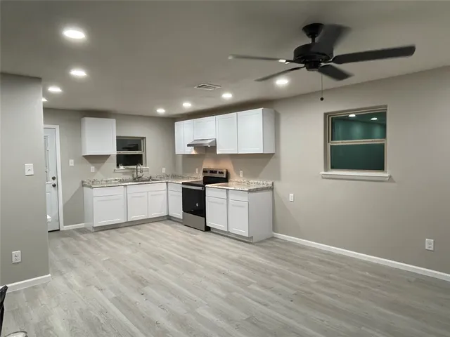 a large kitchen with kitchen island a sink stainless steel appliances and cabinets