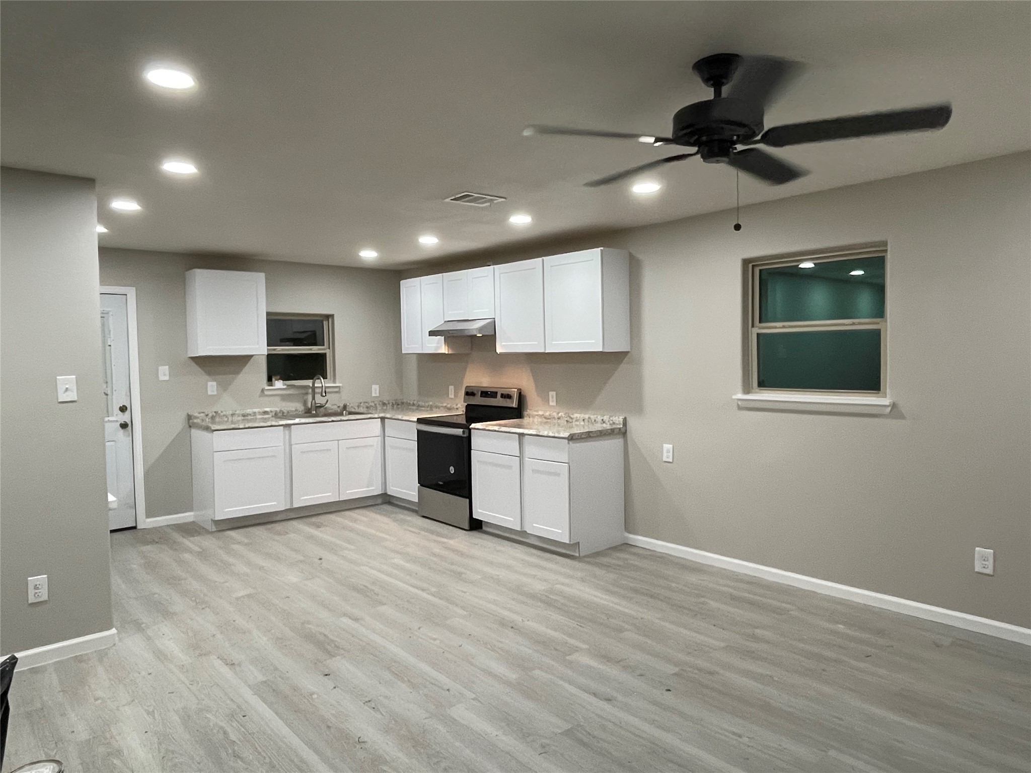 a large kitchen with kitchen island a sink stainless steel appliances and cabinets