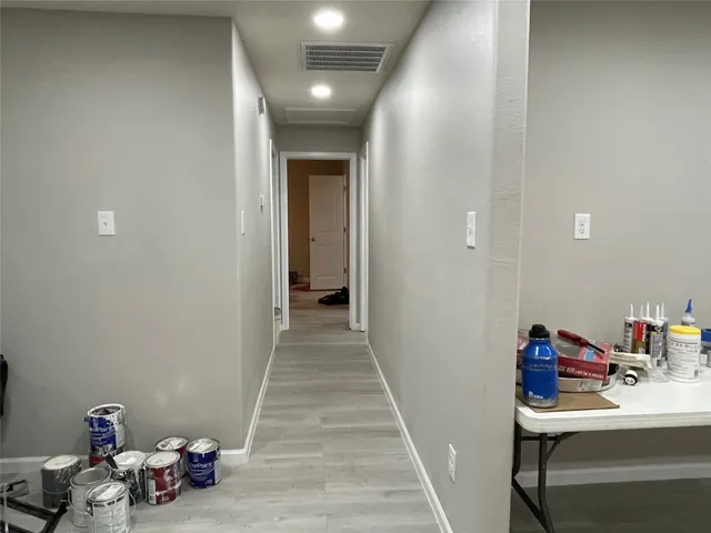 a view of a hallway to the livingroom with wooden floor