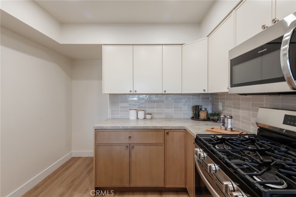 1044 252nd Street, Unit 4 Harbor City, CA 90710 - Photo 16 of 41 a kitchen with stainless steel appliances a stove a microwave and cabinets