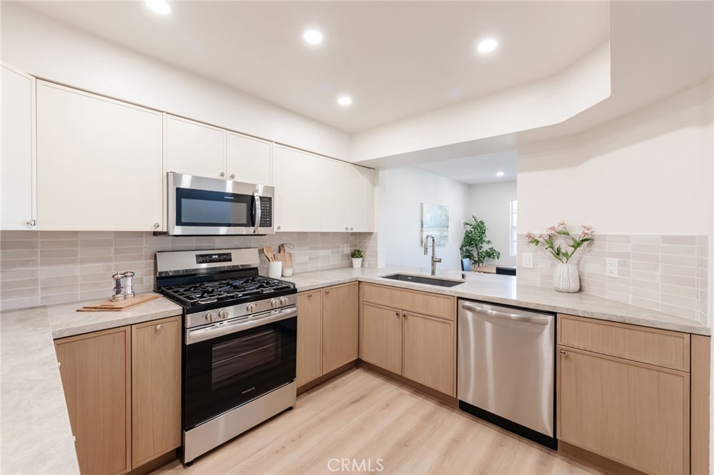 1044 252nd Street, Unit 4 Harbor City, CA 90710 - Photo 22 of 41 a kitchen with white cabinets appliances and sink