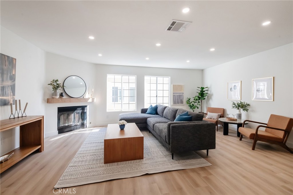 1044 252nd Street, Unit 4 Harbor City, CA 90710 - Photo 24 of 41 a living room with furniture a fireplace and wooden floor