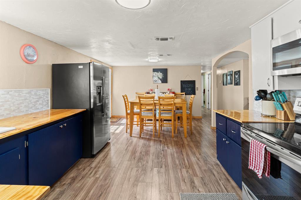 108 Paige Street Weatherford, TX 76088 - Photo 11 of 34 a kitchen with stainless steel appliances granite countertop a table chairs and a refrigerator