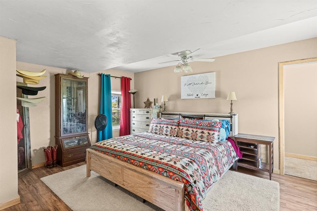 108 Paige Street Weatherford, TX 76088 - Photo 15 of 34 a bedroom with a large bed and a chandelier