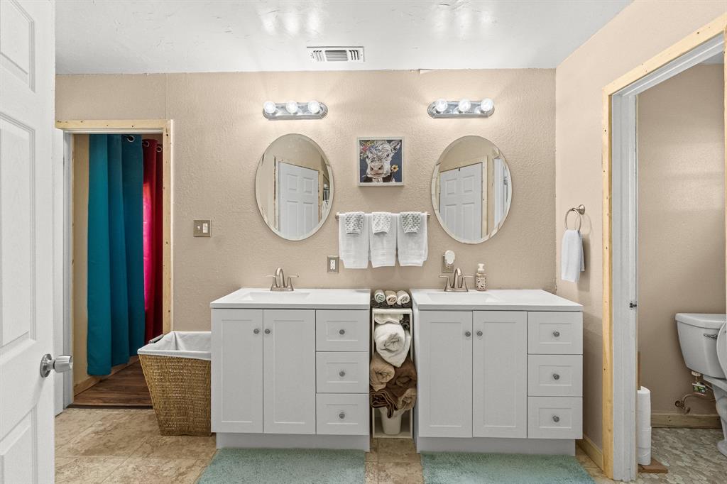 108 Paige Street Weatherford, TX 76088 - Photo 16 of 34 a en suite bathroom with a double vanity sink and a mirror