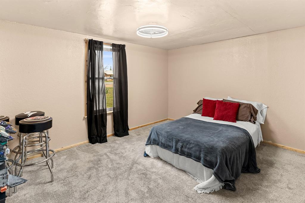 108 Paige Street Weatherford, TX 76088 - Photo 20 of 34 a bedroom with a bed and a chair