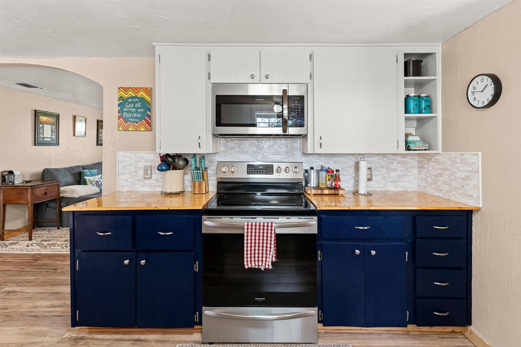 108 Paige Street Weatherford, TX 76088 - Photo 10 of 34 a kitchen with stainless steel appliances granite countertop a stove a sink and a microwave
