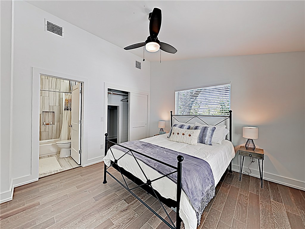5314 Downs Drive, Unit A Austin, TX 78721 - Photo 14 of 19 a bedroom with a bed and wooden floor