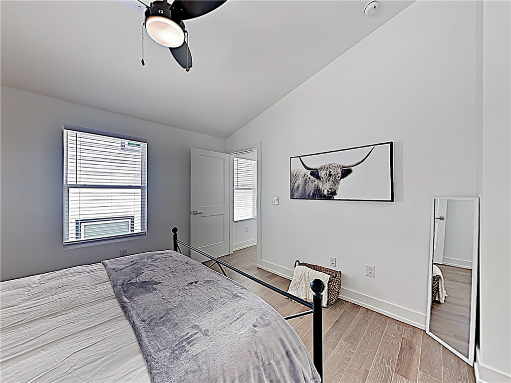 5314 Downs Drive, Unit A Austin, TX 78721 - Photo 15 of 19 a bedroom with a bed and wooden floor